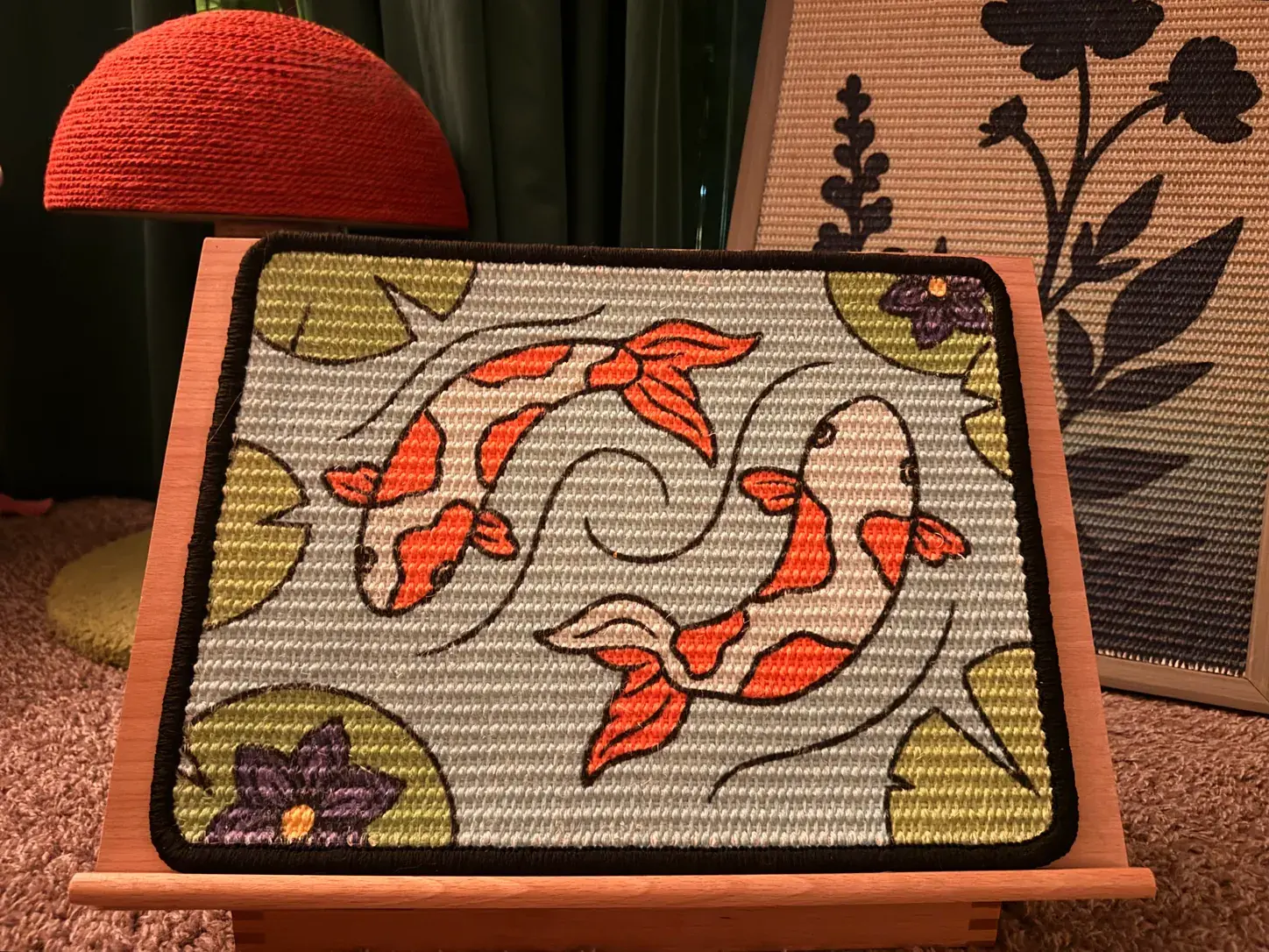 Koi Scratch Canvas panel displayed on its adjustable wooden easel beside a red lamp and framed botanical artwork.