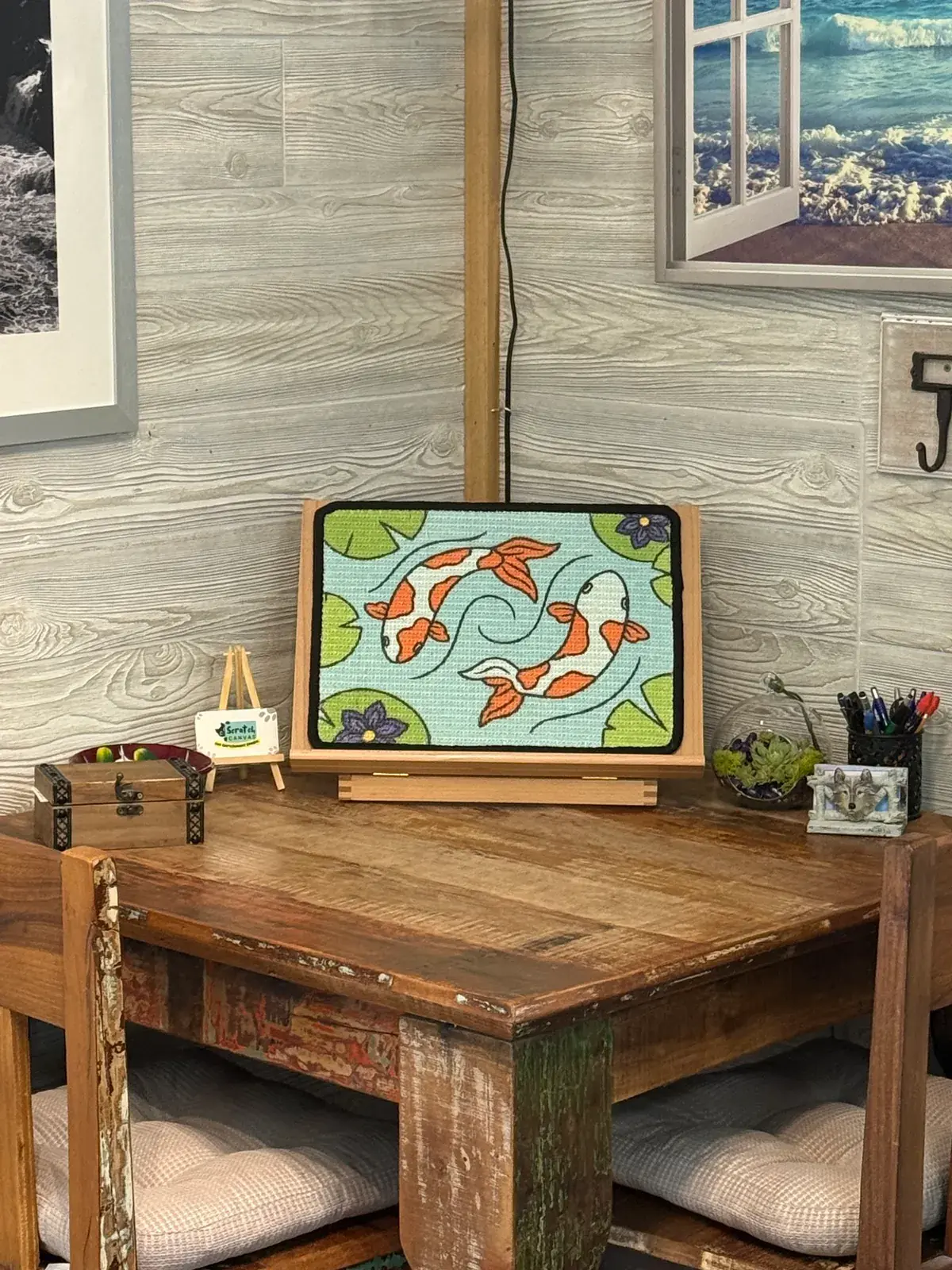 Koi Scratch Canvas displayed on its wooden easel in a furnished salon interior.