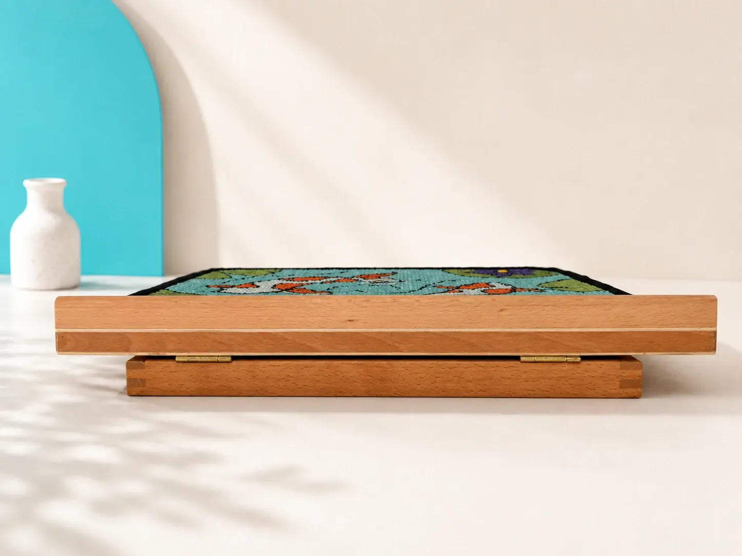 Low-angle view of the Koi scratch panel lying nearly flat on the wooden easel.