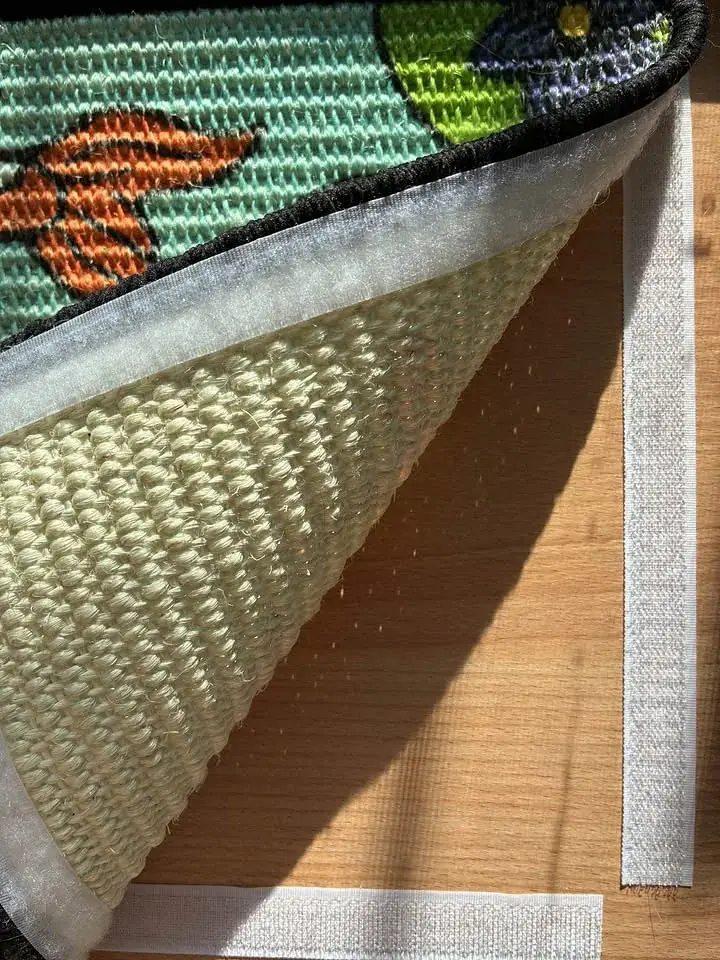 Close view of a Koi scratch panel lifted from the wooden easel, showing the hook-and-loop fastening strips underneath.