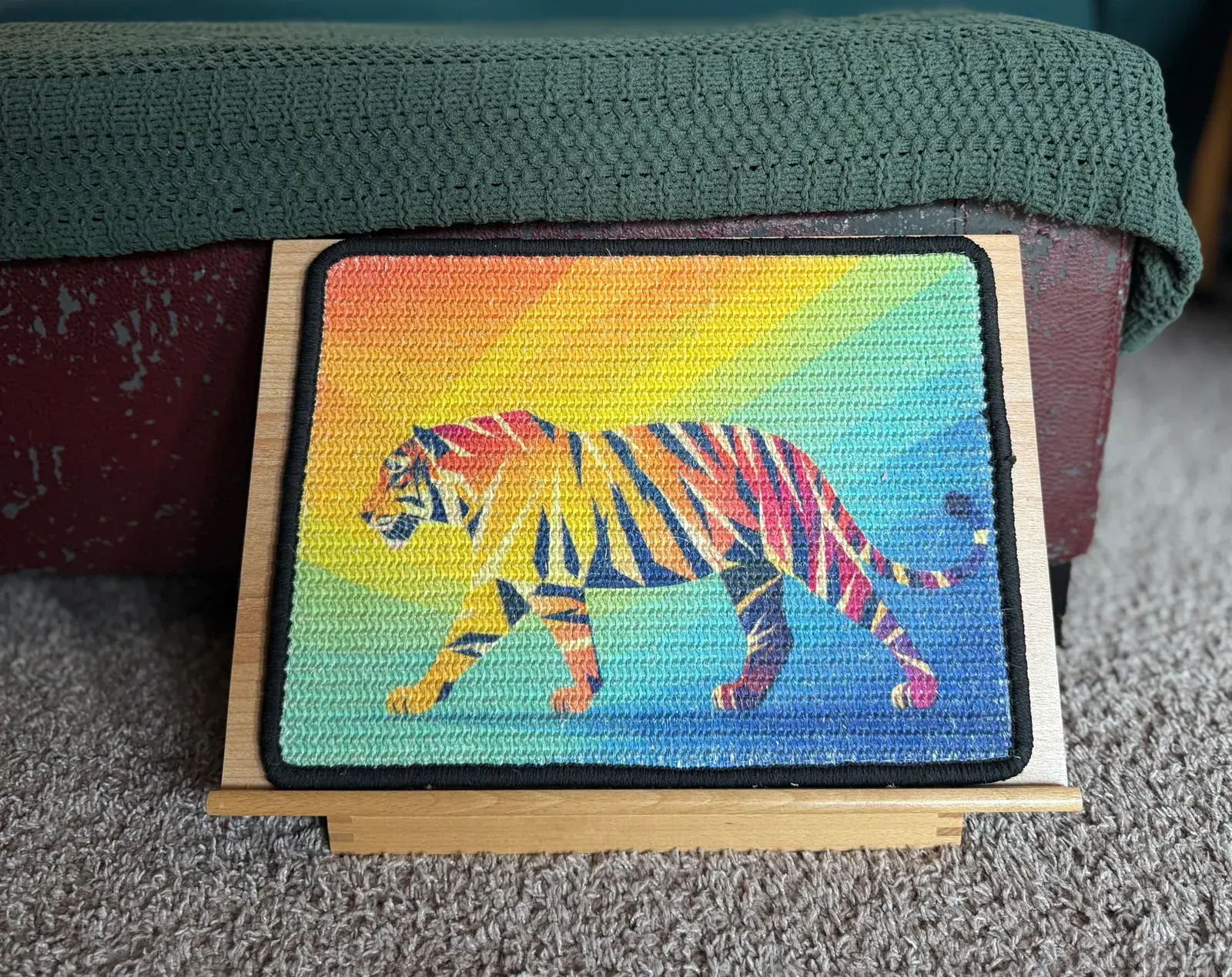 Tiger Scratch Canvas on a wooden easel beside the ottoman Theo scratched.